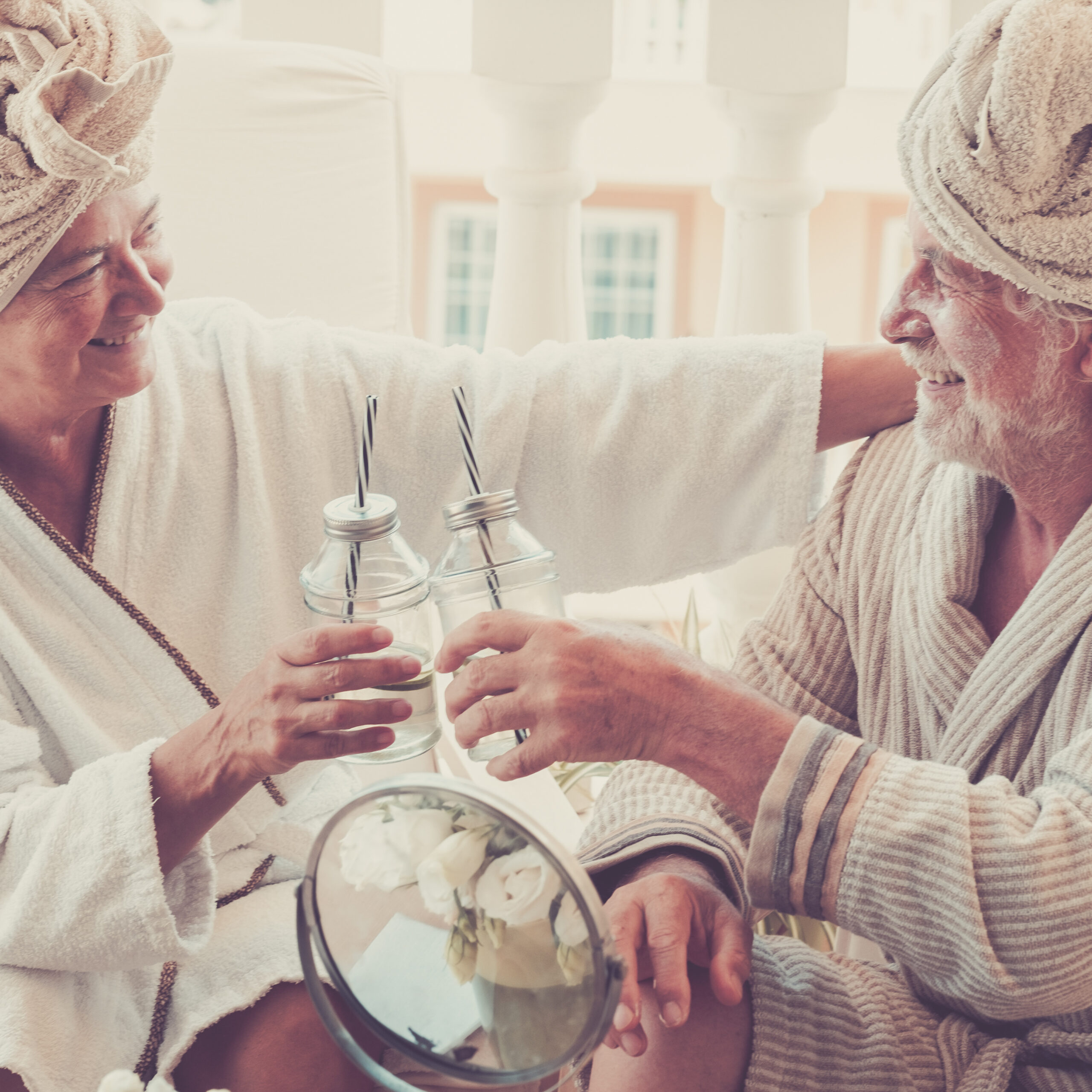 couple of two seniors in a resort or hotel drinking a cocktail a
